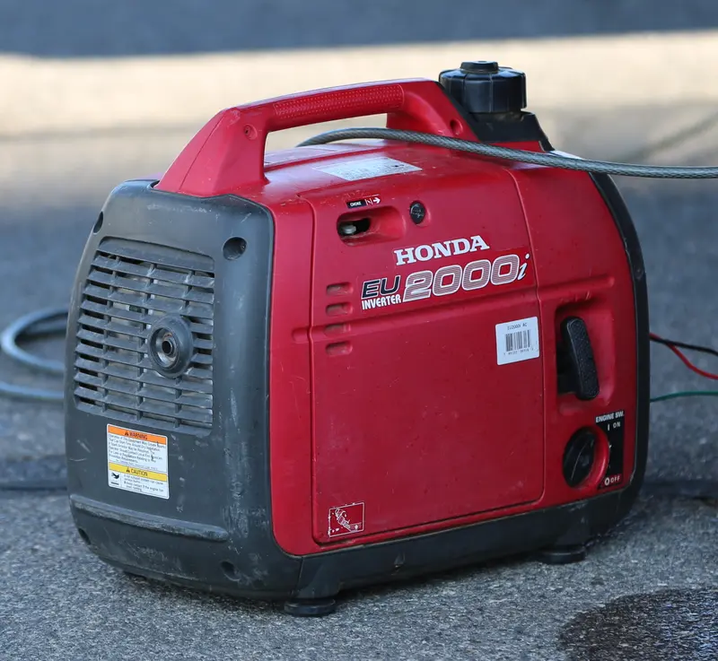 A small red Honda EU2000i portable inverter generator