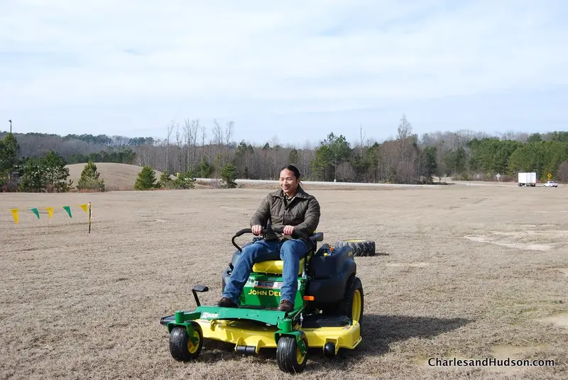 A green zero-turn riding mower with twin steering levers