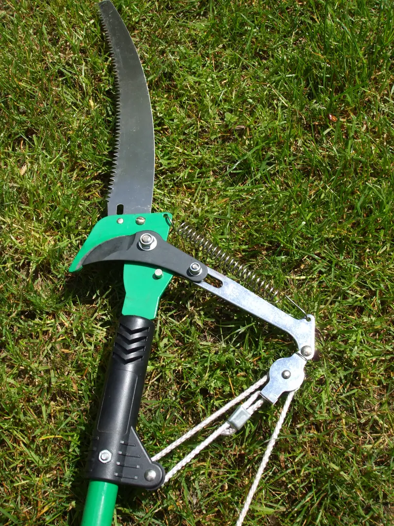 A manual pole saw with a curved blade, lopper, and rope pull