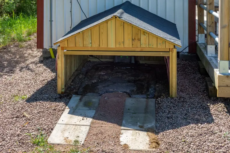 A robotic mower parked at its charging dock beside a lawn