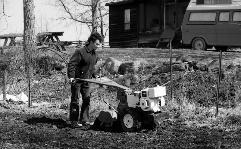 A rototiller working soil in a home garden plot