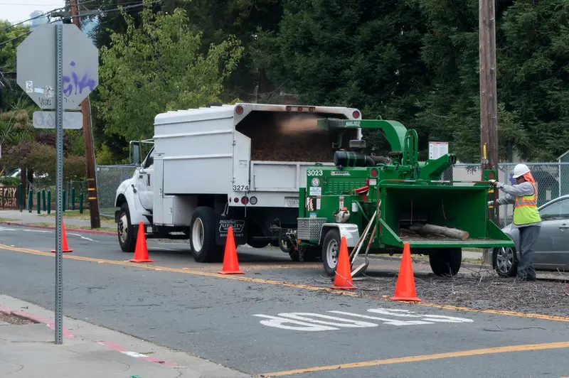 A person operating a wood chipper on a street