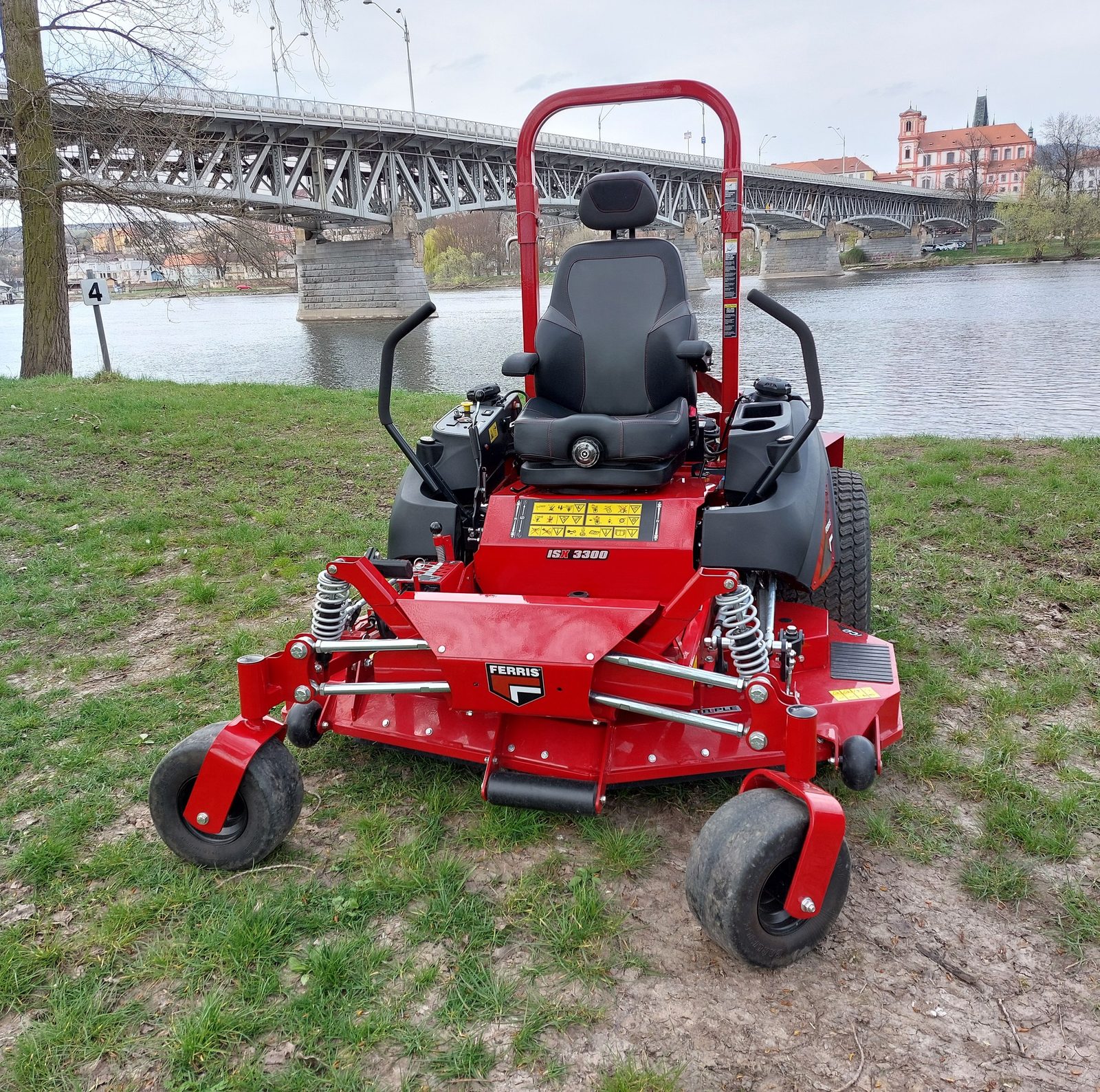A zero-turn riding mower on a large open lawn