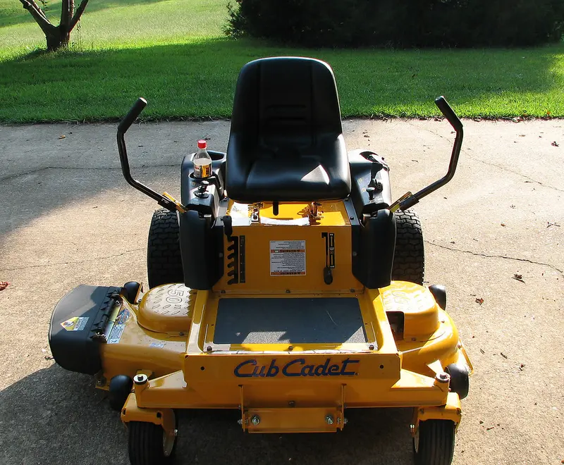 A zero-turn mower parked in a residential backyard
